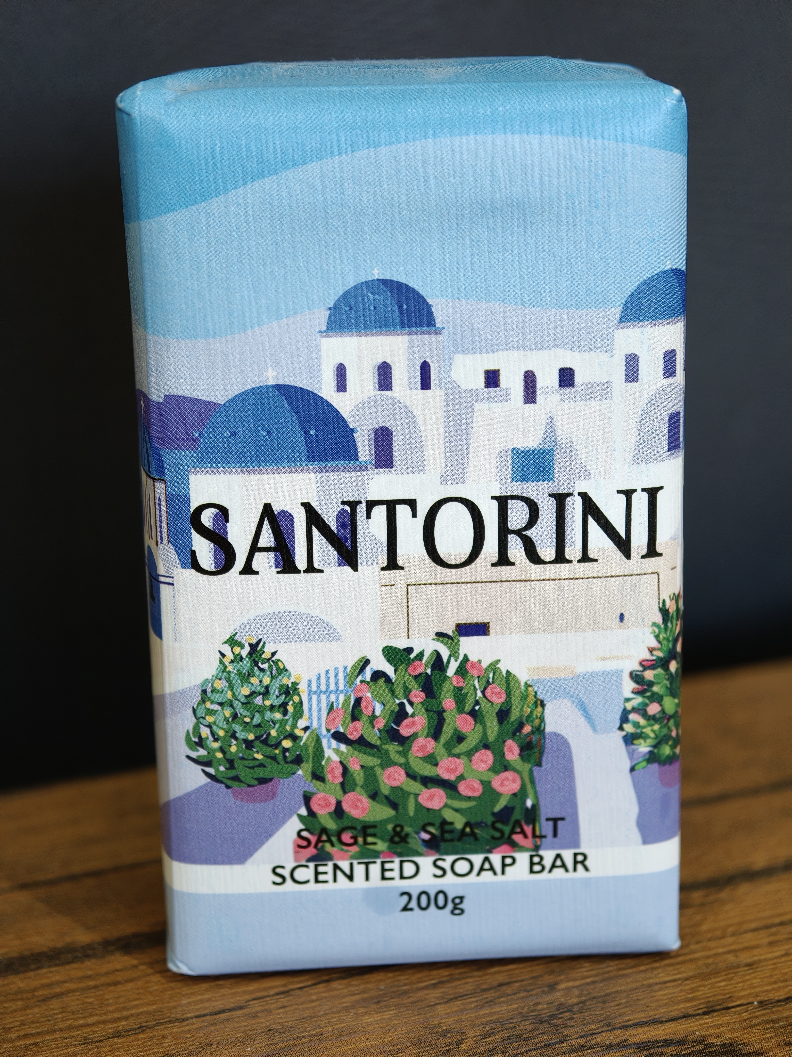 A bar of soap in its wrapper, labelled “Santorini”, with a stylised drawing of iconic buildings from the town of Santorini in Greece