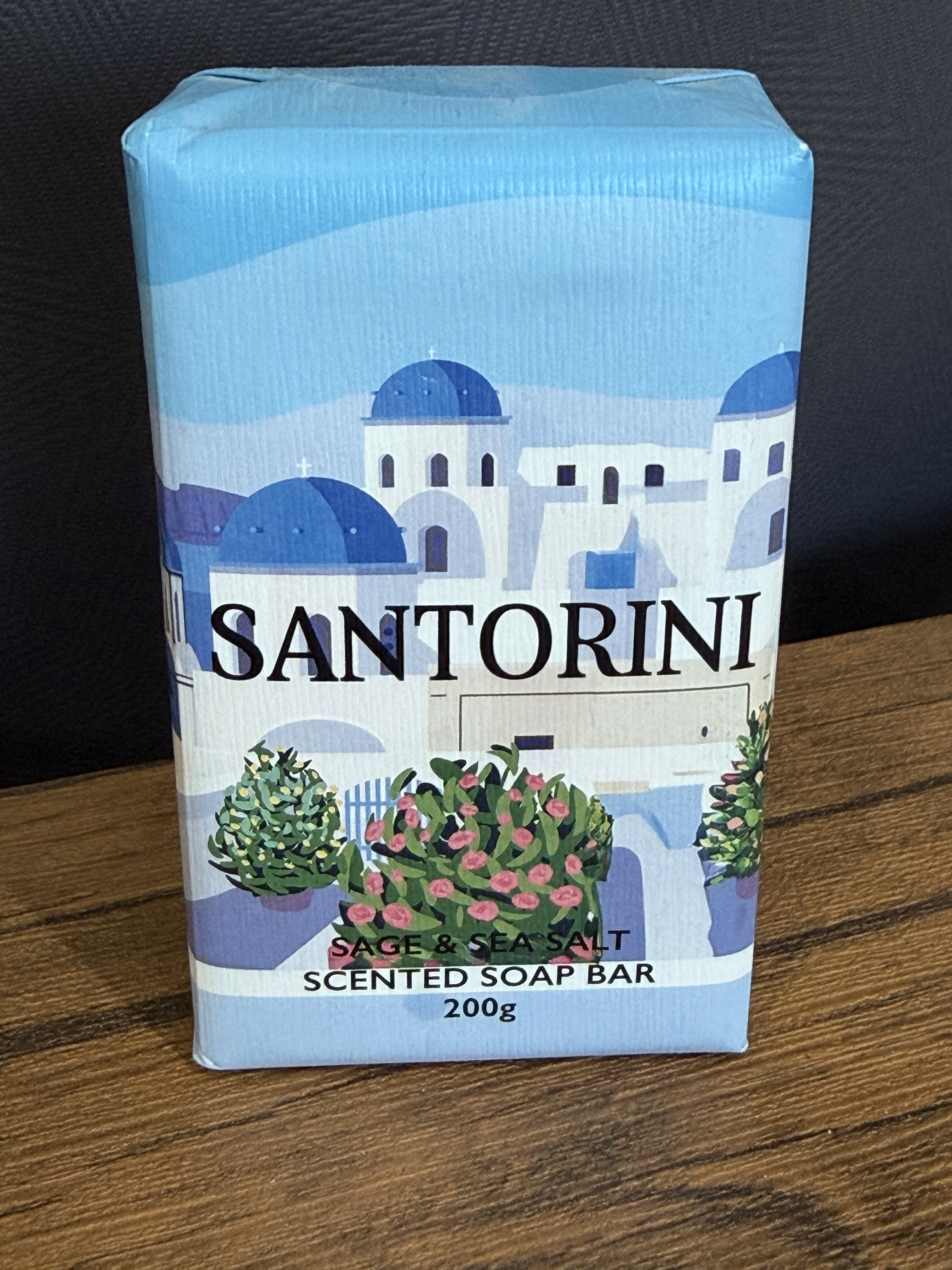 A bar of soap in its wrapper, labelled “Santorini”, with a stylised drawing of iconic buildings from the town of Santorini in Greece